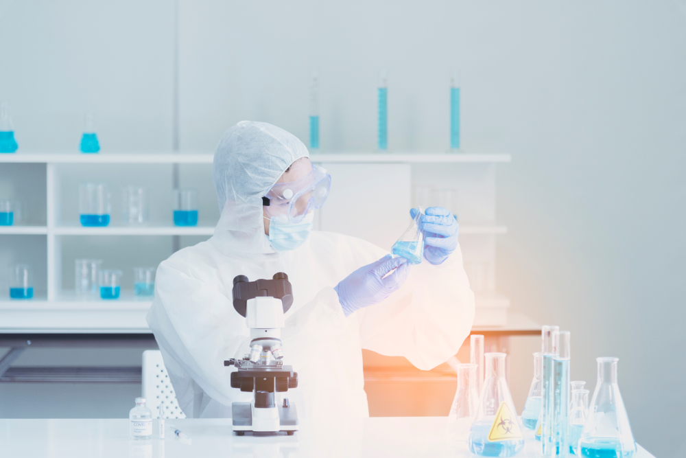 Scientist in laboratory looks at test tube with blue liquid