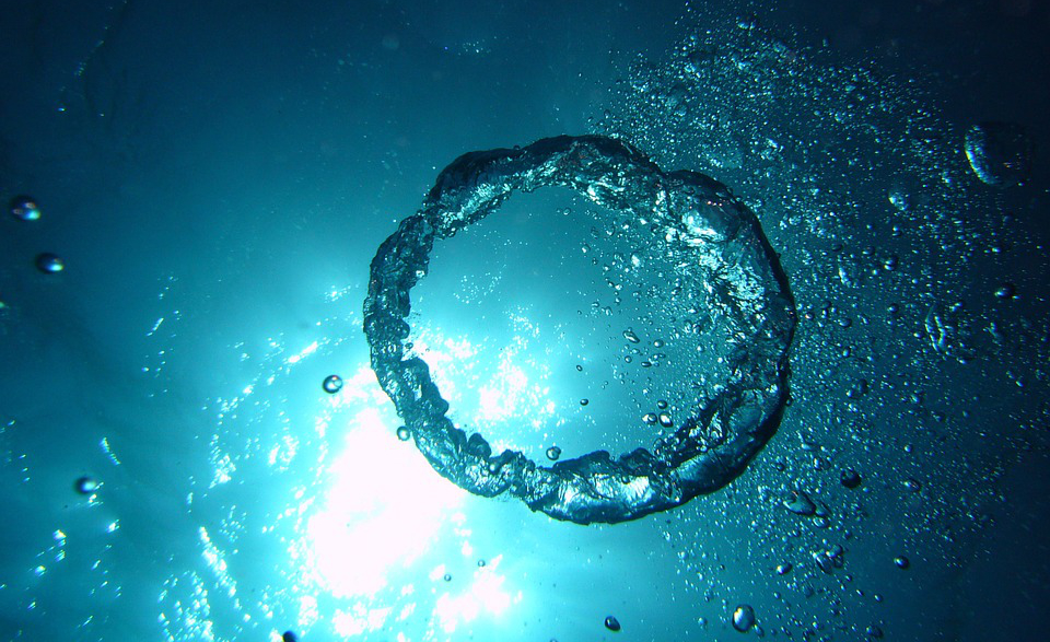 the picture shows several air bubbles and a ring of air under water