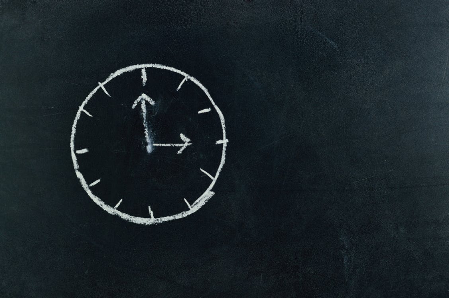 Analogue clock drawn on a blackboard with chalk