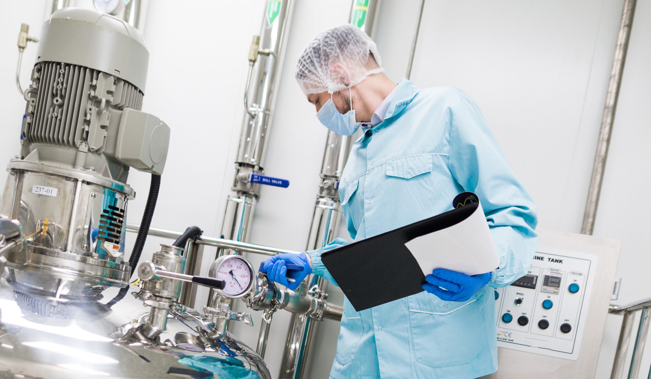 scientist in blue lab suit and gas mask look at steel tank