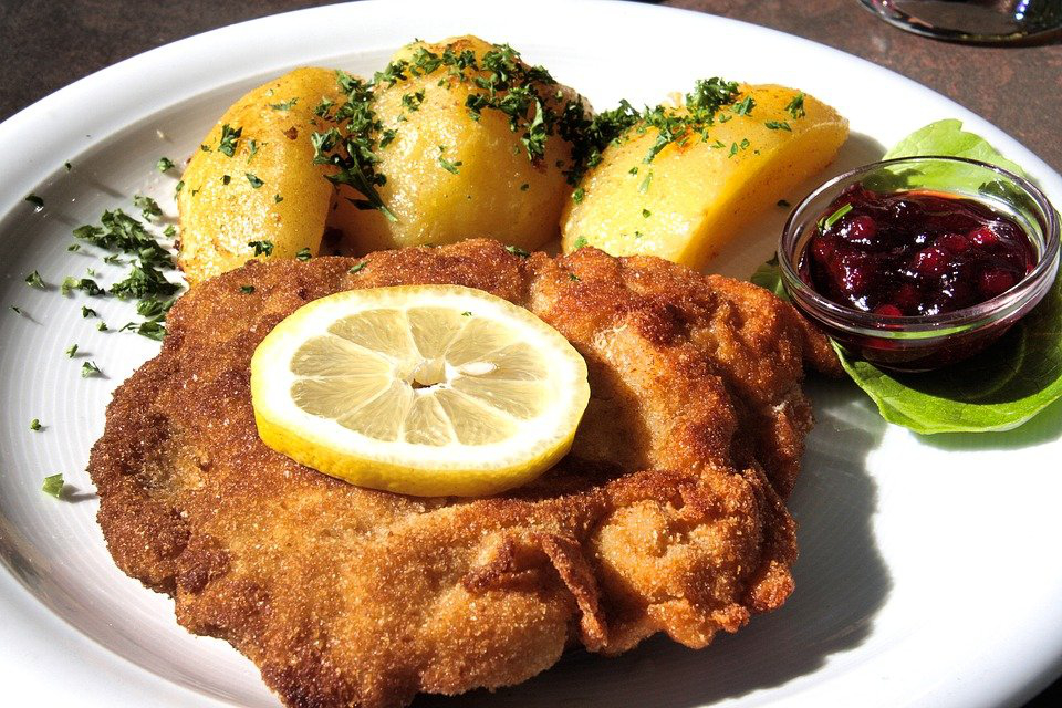 Wienerschnitzel with parsley potatoes and cranberries